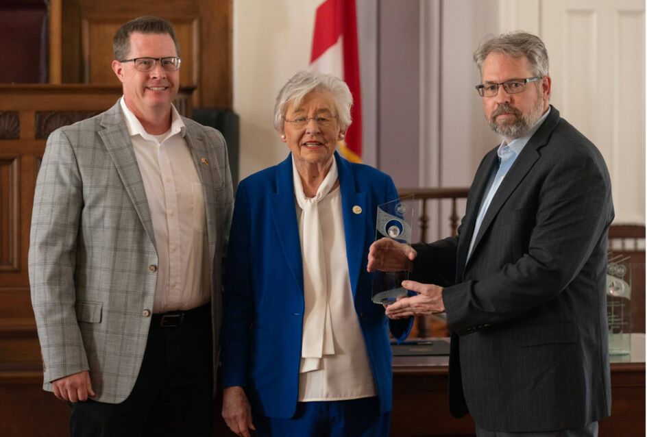 Evonik Birmingham Site Manager Hans Thullesen (left) and Mobile Site Manager Kel Boisvert (right) accept the 2024 Governor's Trade Excellence Award from Alabama Governor Kay Ivey.